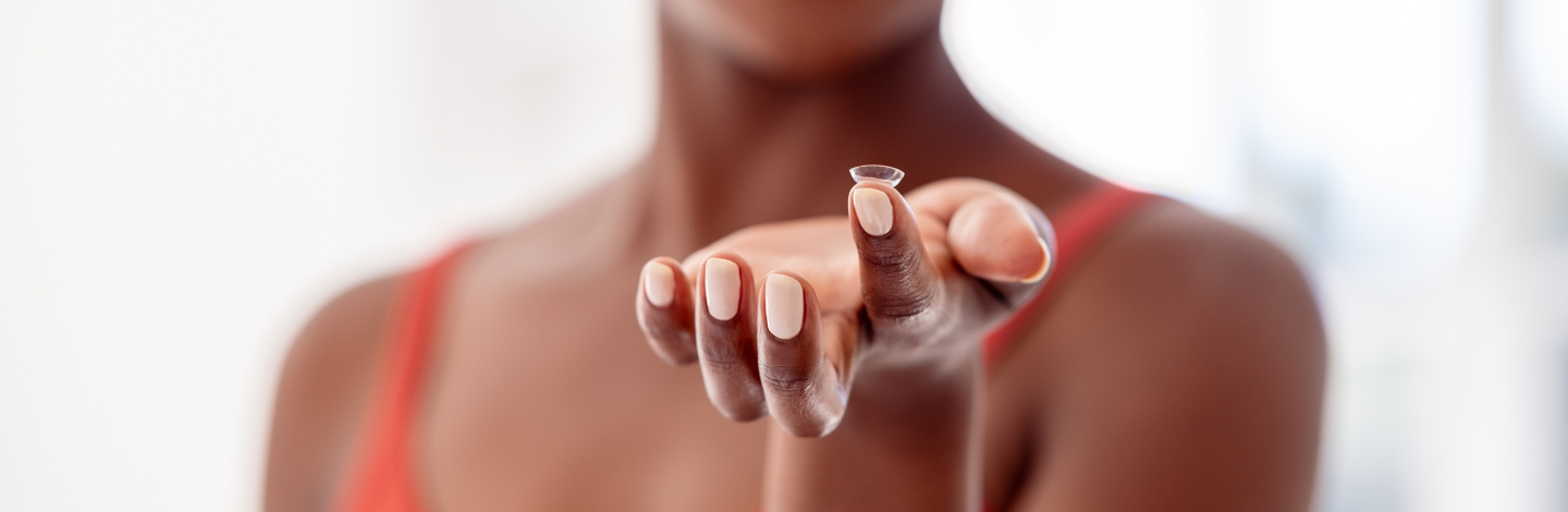 woman holds contact lens