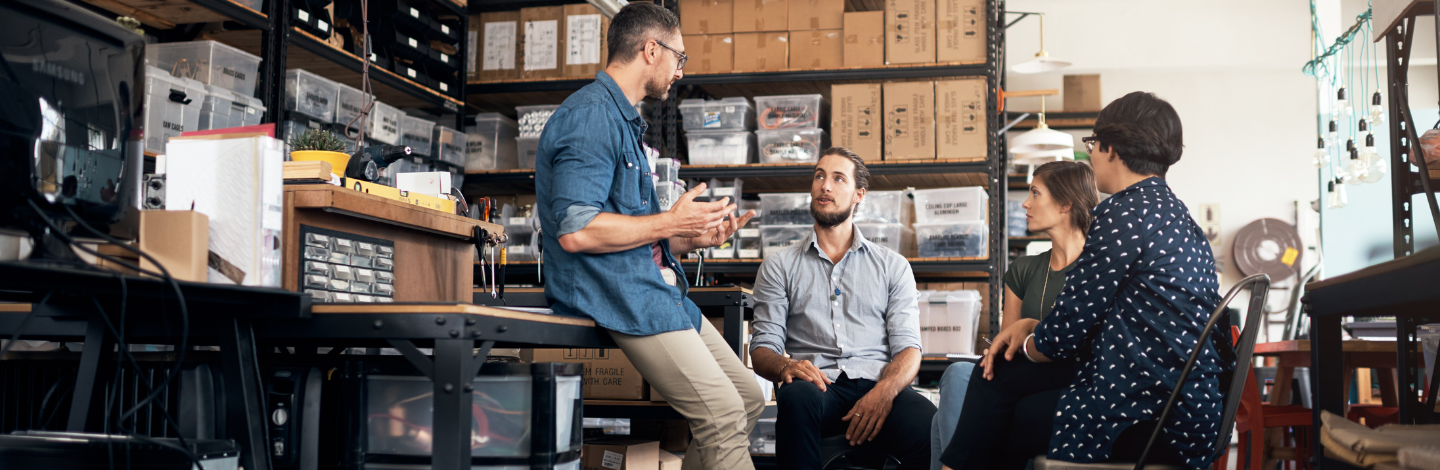group of employees talks in warehouse