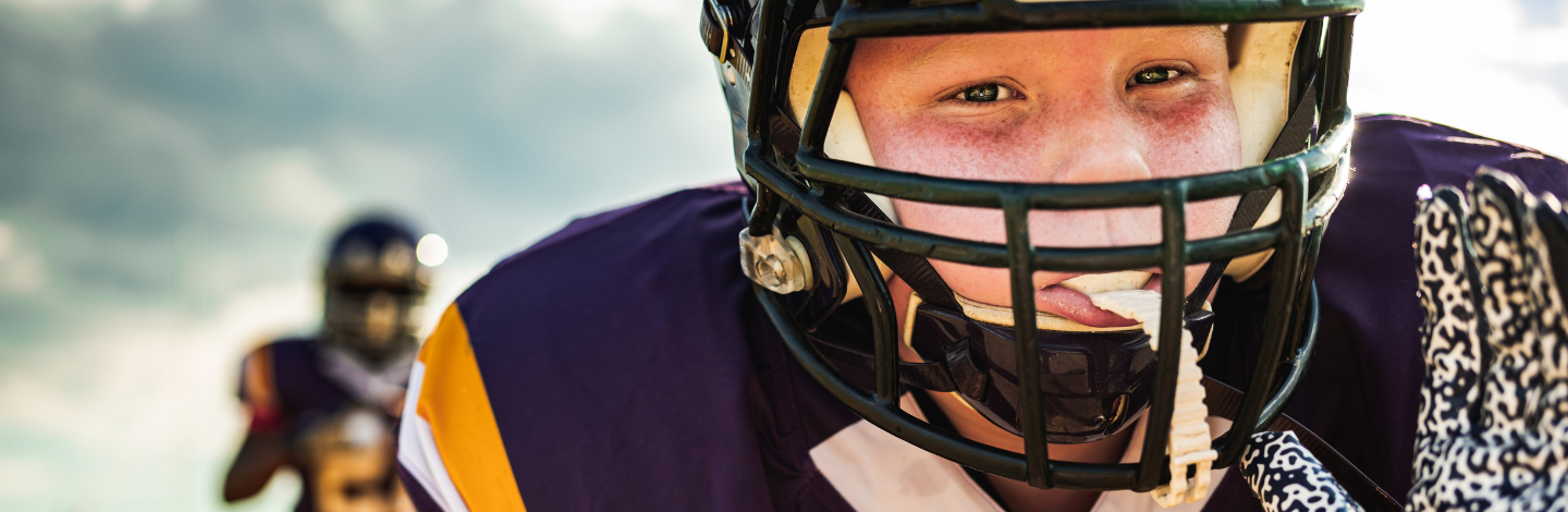 youth football player wears helmet and mouthguard