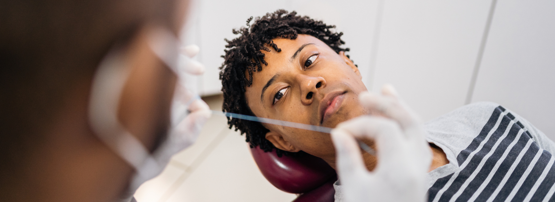 Dentist demonstrating flossing to a patient