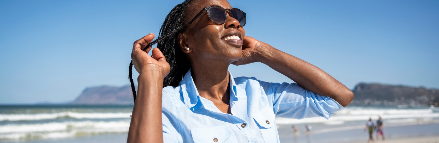 Woman wears sunglasses on beach