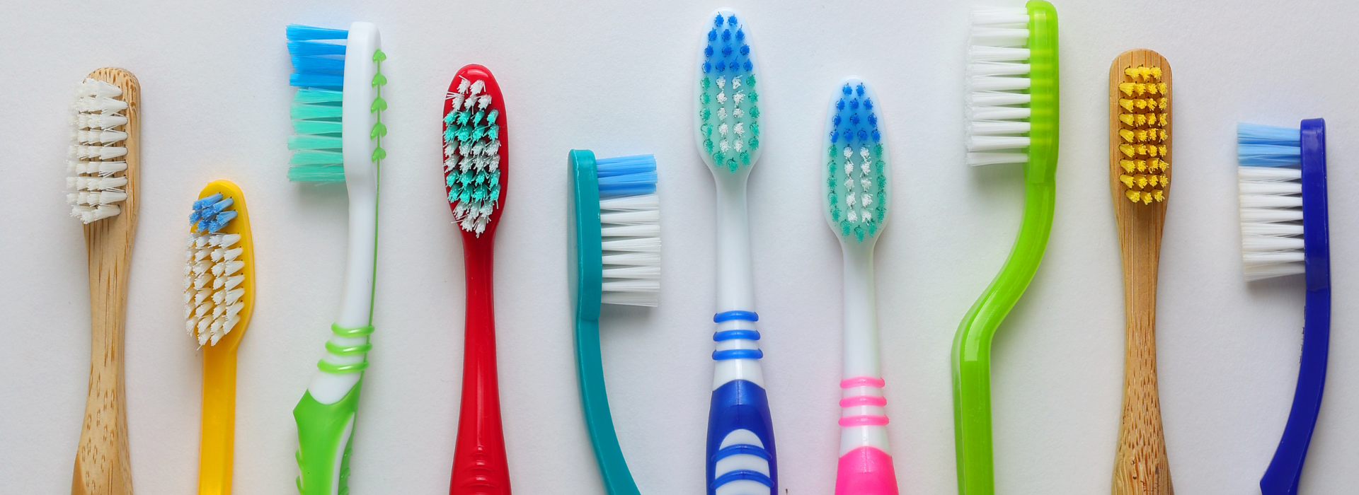 Different toothbrushes on a colored background.