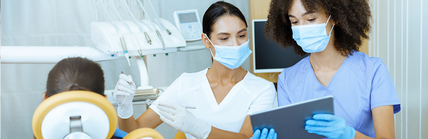 Two dental professionals look at ipad