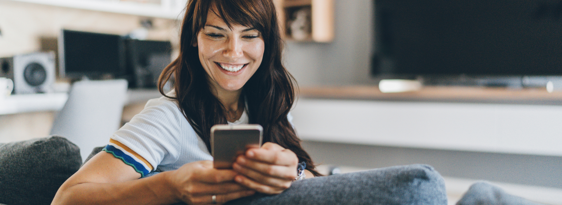 Woman smiles at phone after buying insurance plan