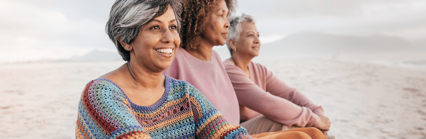 Three women smiling on the beach