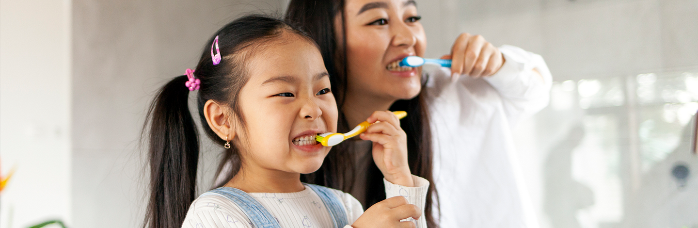 mom and daughter brush teeth in the morning