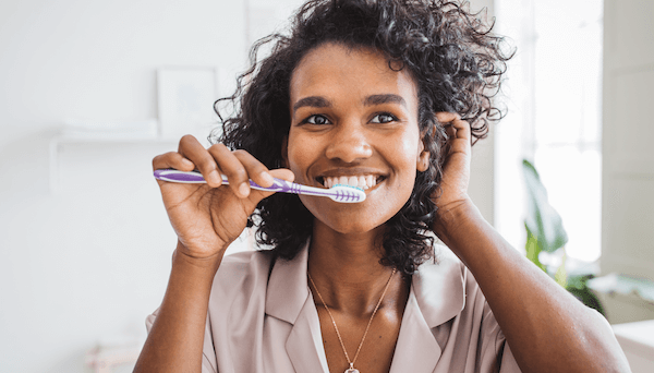 woman-smiling-brushing-teeth-1200x683