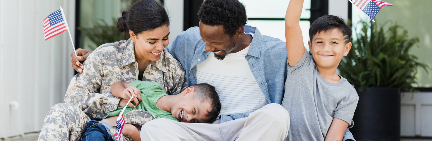 Smiling family with a military mom celebrates with American flags