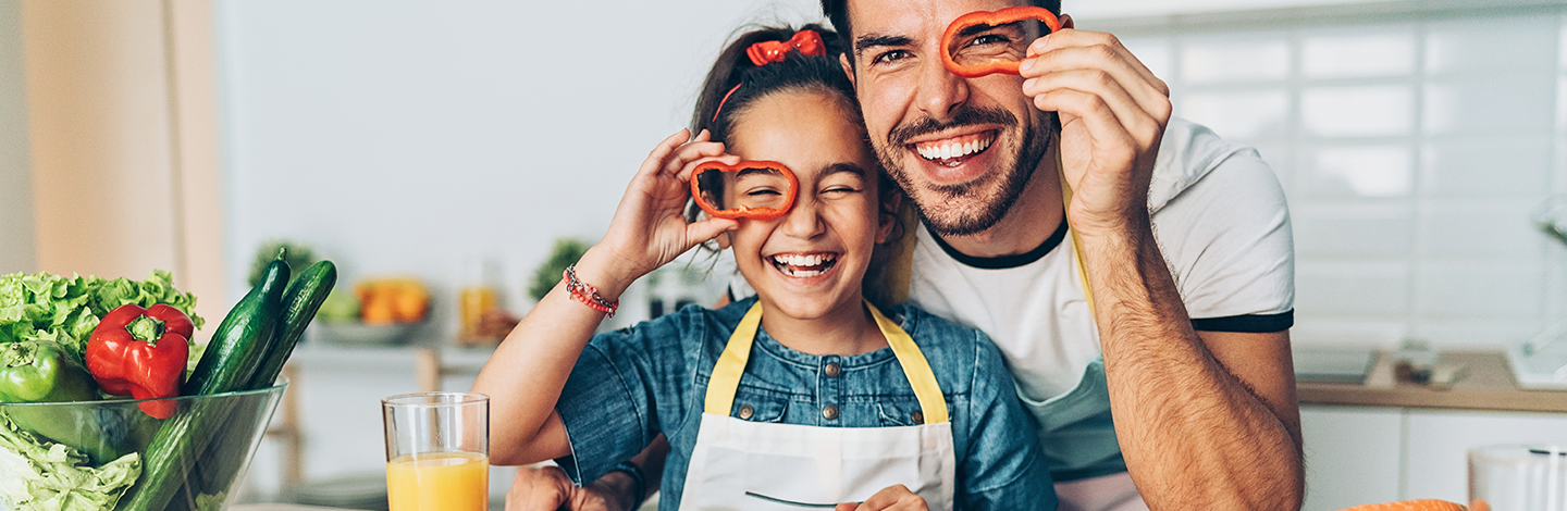 Young girl and dad hold up bell peppers