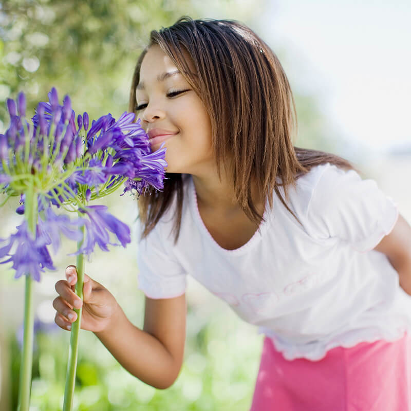 girl-smelling-flowers-800x800