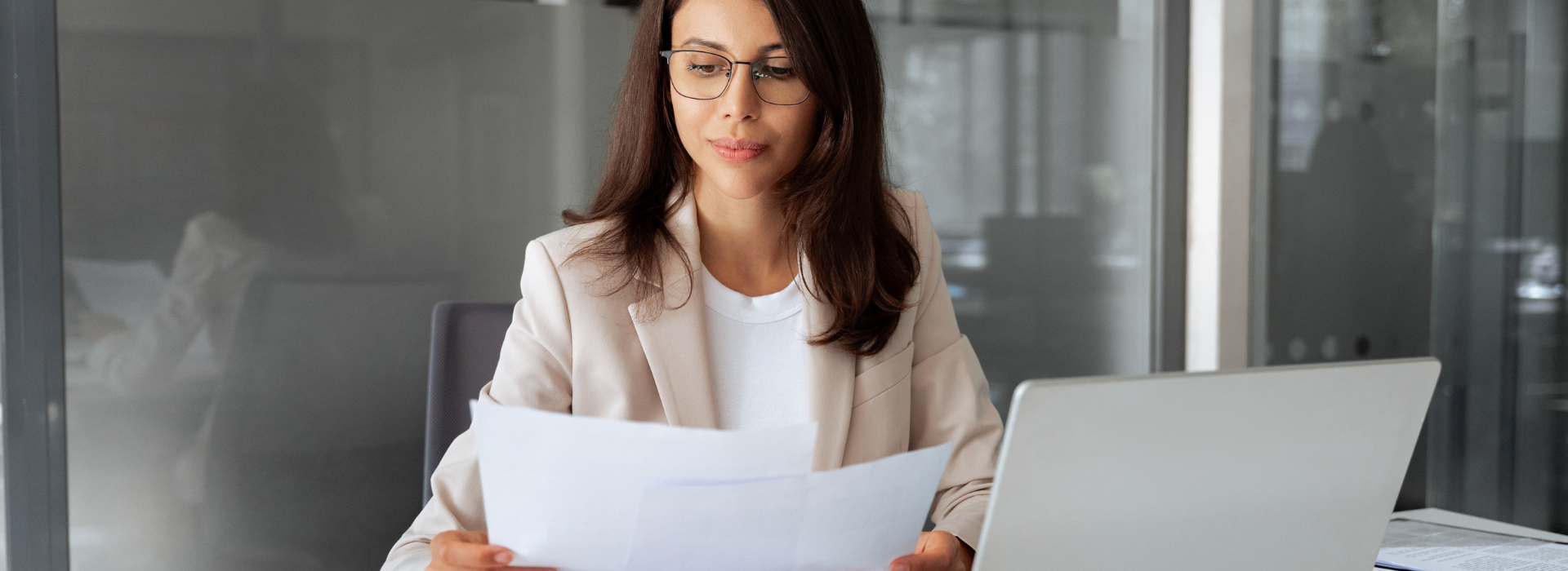 Concentrated business woman saleswoman working on laptop computer reading documents