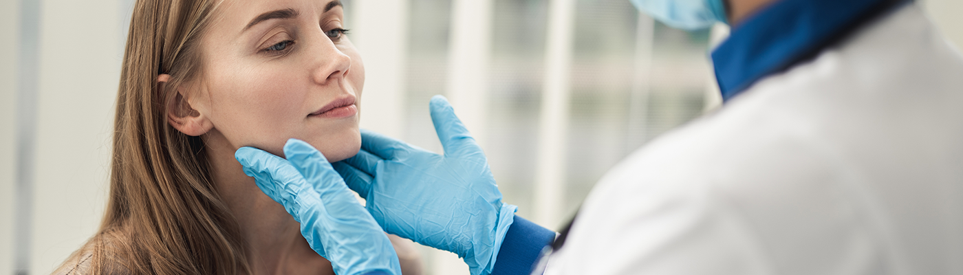 dentist checks patient for oral cancer