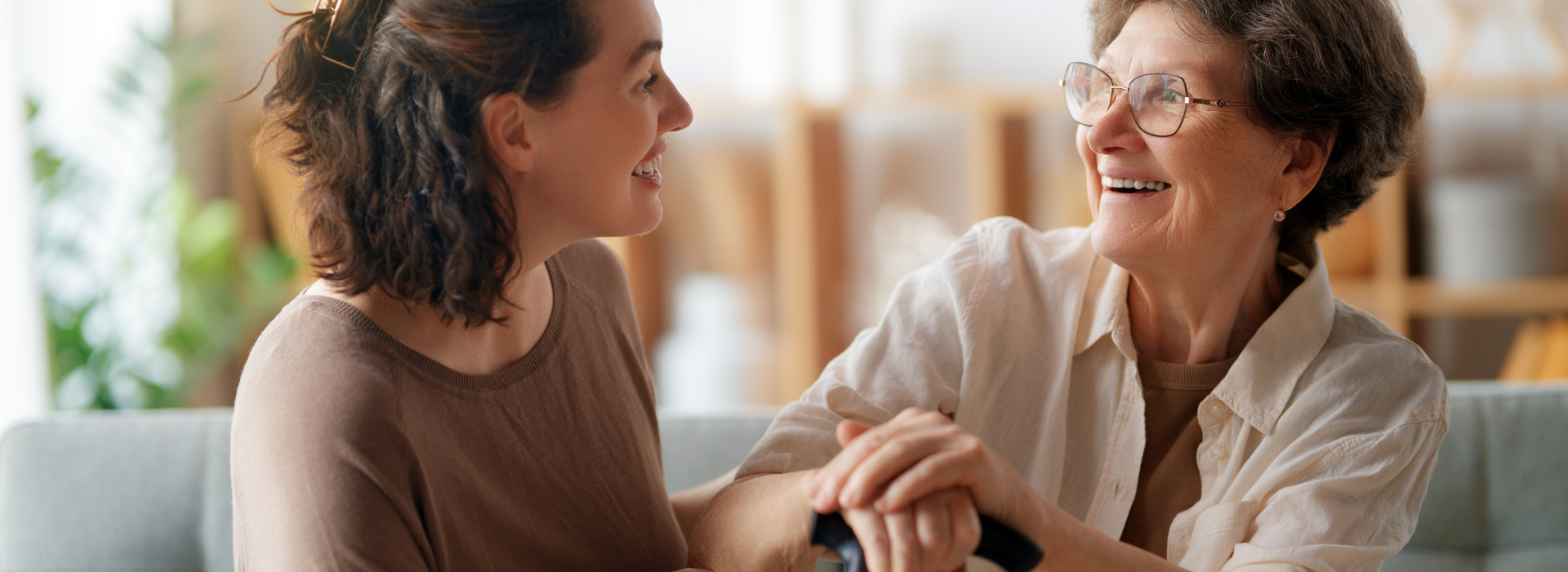 Happy patient and caregiver spending time together. Senior woman holding cane.