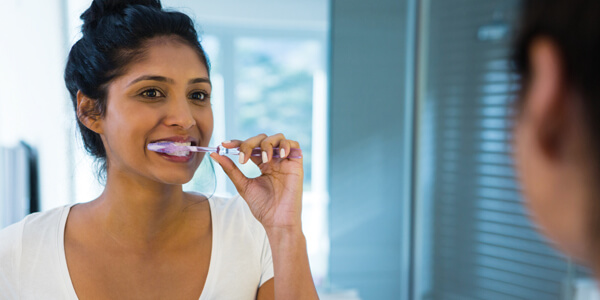 woman-brushing-teeth-600x300