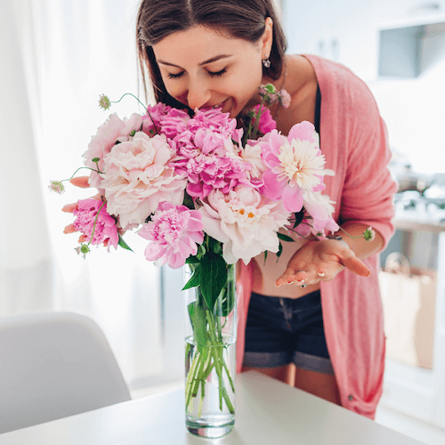 woman-smelling-flowers-800x800